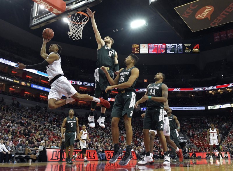 Louisville forward Dwayne Sutton (24) attempts a layup around the defense of Michigan State forward Kyle Ahrens (0) during the second half of an NCAA college basketball game, in Louisville, Ky., Tuesday, Nov. 27, 2018. Louisville won 82-78. (AP Photo/Timothy D. Easley)