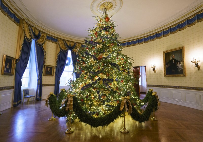 The official White House Christmas tree is seen in the Blue Room during the Christmas press preview at the White House in Washington on Nov. 26. The tree measures 18 feet tall and is dressed in over 500 feet of blue velvet ribbon embroidered in gold with each State and territory. (AP Photo/Carolyn Kaster)

