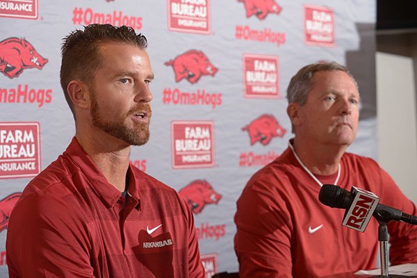 Newly hired Arkansas pitching coach Matt Hobbs (left) speaks Wednesday, Nov. 28, 2018, alongside coach Dave Van Horn during a press conference to announce his hire at Baum Stadium in Fayetteville.