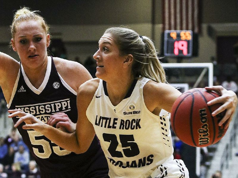 UALR forward Anna Hurlburt (25) drives to the basket past Mississippi State forward Chloe Bibby during the Trojans’ 98-63 loss to the Bulldogs on Wednesday at the Jack Stephens Center in Little Rock.