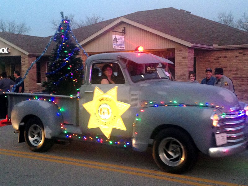 Sally Carroll/McDonald County Press Staff from the McDonald County Sheriff's Office decorate and show off an old truck during last year's Christmas Parade in Pineville.