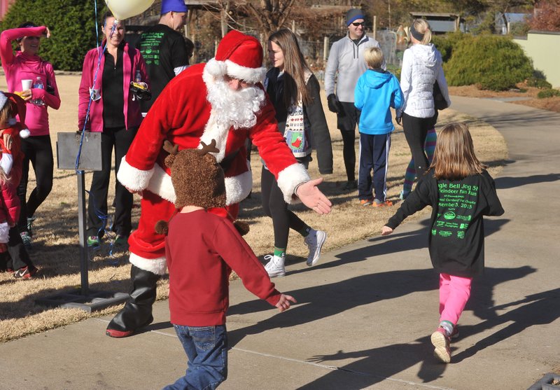 Santa Claus gives high fives to the kids as they cross the finish line during a previous Reindeer Fun Run at the Botanical Garden of the Ozarks. The Jingle Bell Jog 5K and Reindeer Fun Run Dec. 1 will benefit the garden.