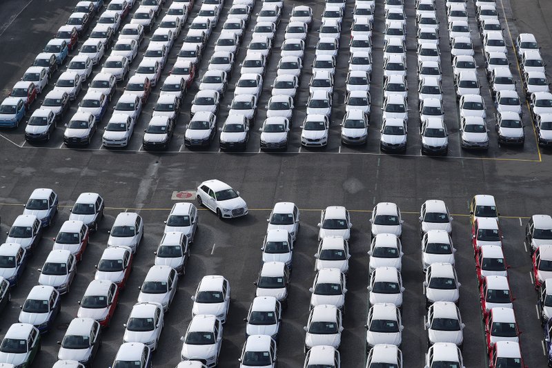 A newly manufactured Audi AG automobile is driven into a parking space as Volkswagen vehicles stand ahead of shipping outside the VW factory at the port in Emden, Germany, on Friday, March 9, 2018. 