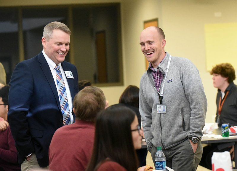 NWA Democrat-Gazette/FLIP PUTTHOFF William Felts (left) and Todd Sisson, both teachers at New Technology High School, chat Wednesday with residents at the Community in Action meeting in Rogers.