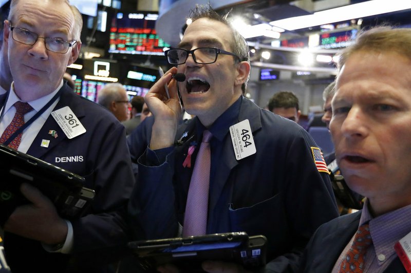 Trader Gregory Rowe, center, works on the floor of the New York Stock Exchange, Thursday, Nov. 29, 2018. U.S. stocks are lower Thursday morning after huge gains the day before. (AP Photo/Richard Drew)