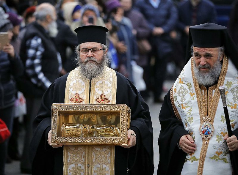 A priest holds the box containing the remains of Holy Hand of St. Andrew, in Bucharest, Romania, on Nov. 24, a day before the dedication of the national cathedral. The “Salvation of the People” cathedral has cost, according to the church, $125 million and will be consecrated Sunday. 