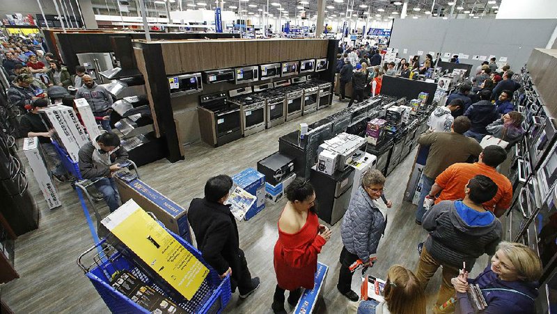 Shoppers line up to check out at a Best Buy store on Thanksgiving Day in Overland Park, Kan. Americans’ spending is expected to keep driving economic growth this quarter.