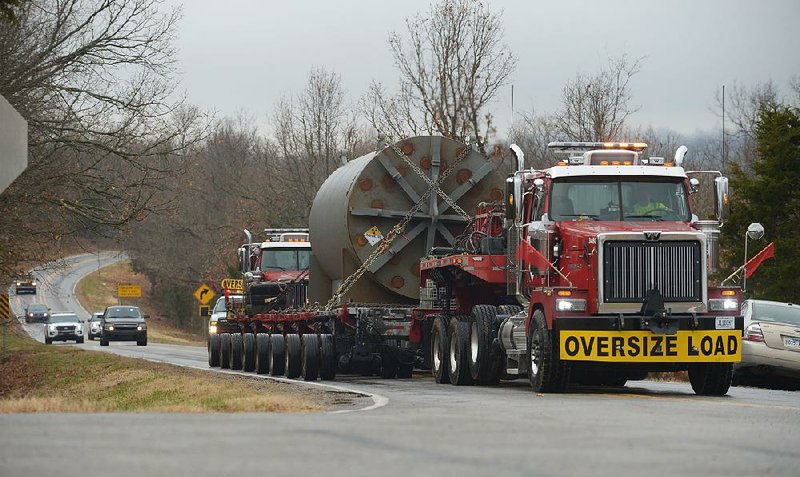 A truck transporting a part of the long-decommissioned University of Arkansas experimental nuclear reactor makes its way Thursday along Arkansas 265 to Arkansas 170 near West Fork in Washington County.