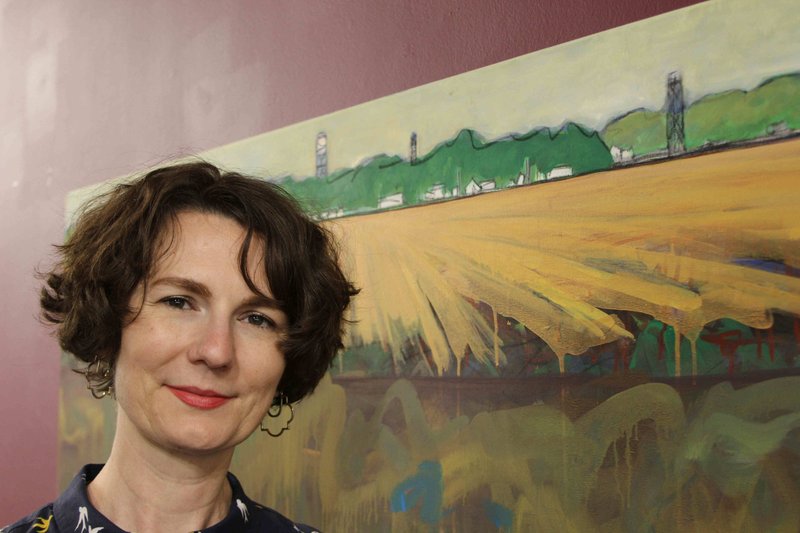 Rachel M. Miller, executive director of the Arts & Science Center for Southeast Arkansas, stands beside Norwood Creech’s "Looking to The Woodz, Lepanto, Poinsett County, Arkansas, 2016," which is charcoal, tinted gesso and metallic gesso on linen. (Special to the Democrat-Gazette/DEBORAH HORN)