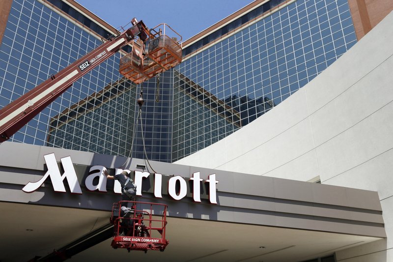 FILE - In this Tuesday, April 30, 2013, file photo, a man works on a new Marriott sign in front of the former Peabody Hotel in Little Rock, Ark. Marriott says the information of up to 500 million guests at its Starwood hotels has been compromised. It said Friday, Nov. 30, 2018, that there was a breach of its database in September, but also found out through an investigation that there has been unauthorized access to the Starwood network since 2014. (AP Photo/Danny Johnston, File)

