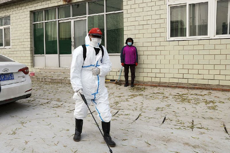 A worker sprays disinfectant near a sealed-off pig farm last month on the outskirts of Beijing as an African swine flu outbreak continues to curtail pork production in China. 