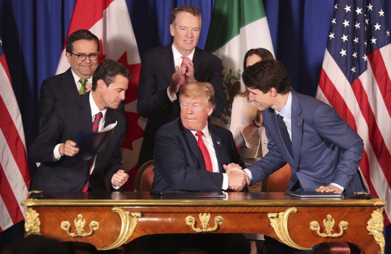 President Donald Trump, center, shakes hands with Canada's Prime Minister Justin Trudeau as Mexico's President Enrique Pena Nieto looks on after they signed a new United States-Mexico-Canada Agreement that is replacing the NAFTA trade deal, during a ceremony at a hotel before the start of the G20 summit in Buenos Aires, Argentina, Friday, Nov. 30, 2018. The USMCA, as Trump refers to it, must still be approved by lawmakers in all three countries. (AP Photo/Martin Mejia)