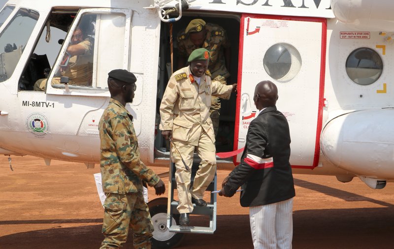 In this photo taken Thursday, Nov. 22, 2018, a South Sudan armed opposition commander Ashab Khamis steps off a helicopter before high level talks with government army Gen. Keer Kiir Keer, where both sides exchanged accusations of violating the peace agreement, in Wau, South Sudan. The Associated Press witnessed the first meeting between the Wau region leaders of South Sudan's army and armed opposition since a groundbreaking peace deal, and the country's peace rests on whether the opposing sides can put a vicious past behind. (AP Photo/Sam Mednick)