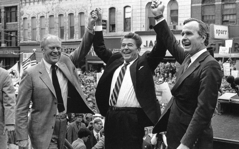 In this Nov. 3, 1980, file photo, former President Gerald Ford lends his support to Republican presidential candidate Ronald Reagan and his running mate, George H.W. Bush in Peoria, Ill. Bush has died at age 94. Family spokesman Jim McGrath says Bush died shortly after 10 p.m. Friday, Nov. 30, 2018, about eight months after the death of his wife, Barbara Bush. (AP Photo, File)