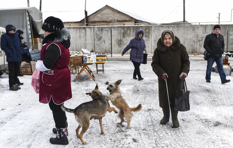 Local people walk through at Saturday's market in Milove, a small town at the border between Ukraine and Russia, in Luhansk region, eastern Ukraine, Saturday, Dec. 1, 2018. (AP Photo/Evgeniy Maloletka)