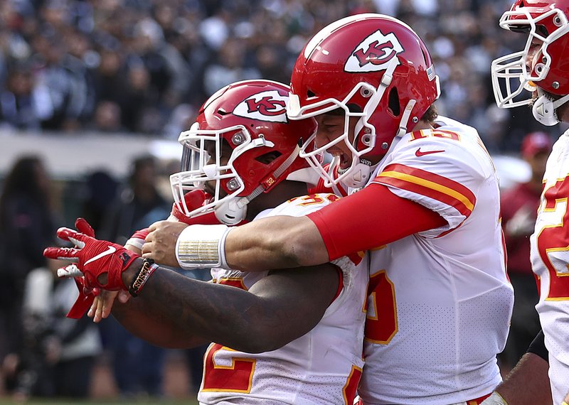 Kansas City Chiefs running back Spencer Ware, left, is congratulated by quarterback Patrick Mahomes after scoring against the Oakland Raiders during the second half of an NFL football game in Oakland, Calif., Sunday, Dec. 2, 2018. (AP Photo/Ben Margot)