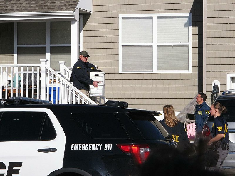 An FBI agent carries cardboard boxes out of the home of Atlantic City, N.J., Mayor Frank Gilliam Jr. on Monday, as part of the execution of a search warrant. 