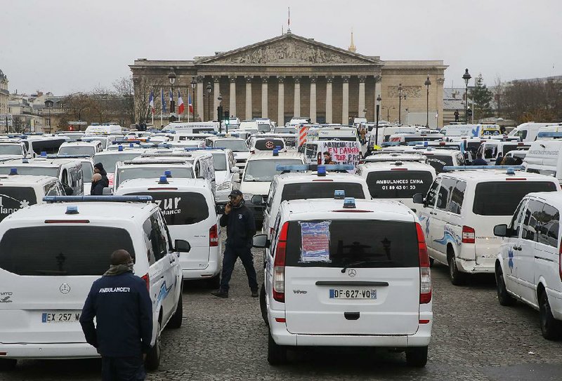 Ambulance workers block the bridge leading the National Assembly in Paris on Monday as many French workers took to the streets and gathered close to the National Assembly in downtown Paris to complain about changes to working conditions. 
