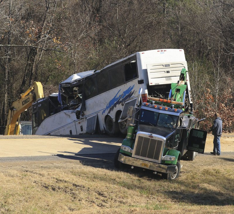 Arkansas Democrat-Gazette/STATON BREIDENTHAL FATAL CRASH: Tow truck operator work Monday to recover a bus involved in a fatal crash on Interstate 30 at mile marker 111 in Saline County.