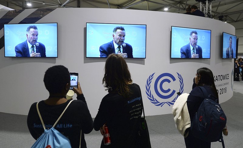 The Associated Press SKY THREAT: Visitors to the U.N. climate conference watch a speech by Arnold Schwarzenegger, in Katowice, Poland, Monday. The COP24 UN Climate Change Conference is taking place in Katowice, Poland. Negotiators from around the world are meeting for talks on curbing climate change.