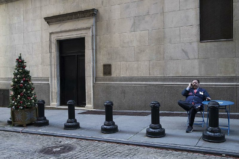 A trader takes a break Tuesday outside the New York Stock Exchange, where stocks tumbled in a sell-off that began after a series of tweets by President Donald Trump, who warned China that “I am a Tariff Man.” 