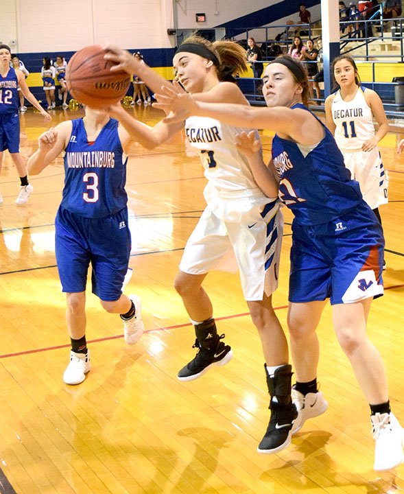 Westside Eagle Observer/MIKE ECKELS Decatur's Destiny Mejia (center) gains control of the ball from a Lady Dragon during the Decatur-Mountainburg basketball contest at Peterson Gym Nov, 28. The Lady Bulldogs lost to the Lady Dragons in the second round of the Decatur Holiday Hoops Basketball Tournament.