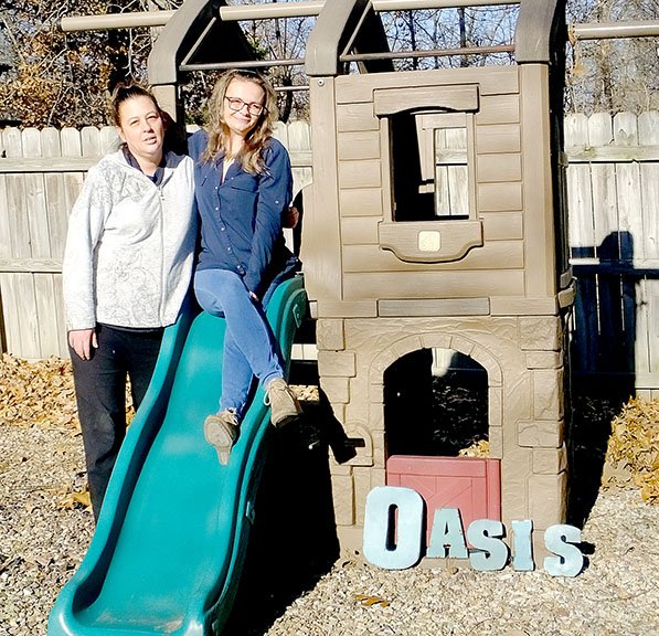 Lynn Atkins/The Weekly Vista Monique Hartley (left), a resident of Oasis, poses with program director Trisha Sanders on a play set that residents' children use. The transitional housing program is going through some changes, but still helping women in need.