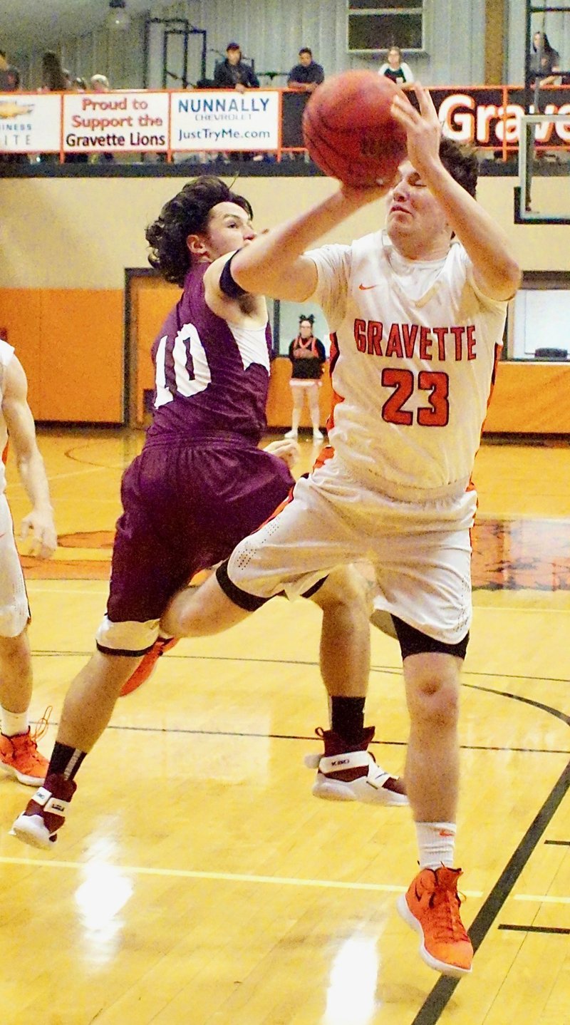 Westside Eagle Observer/RANDY MOLL Gravette's Jake Carver attempts a two-point shot but is fouled by Huntsville's Sean Mccone during Friday's contest between the two teams in Lion Fieldhouse at Gravette.