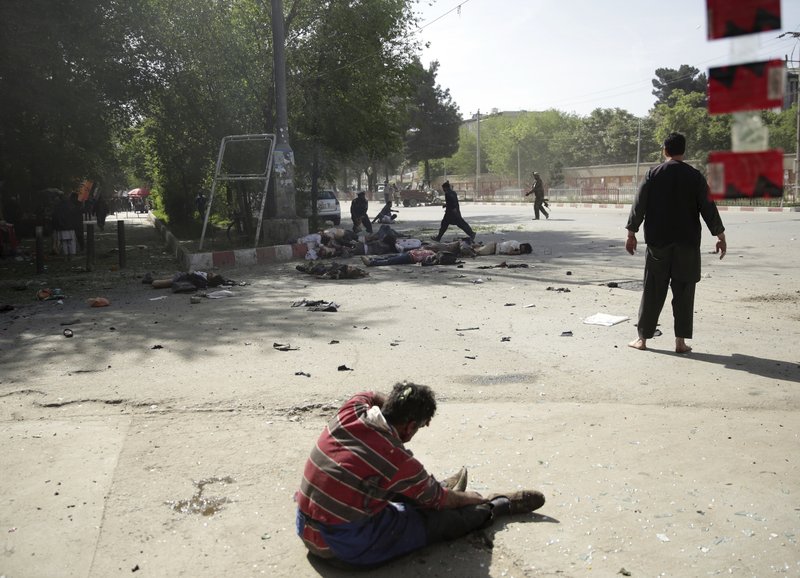 A wounded man sits on the ground after explosions in central Kabul, Afghanistan, on April 30, 2018, following a coordinated double suicide bombing. (AP Photo/Massoud Hossaini)