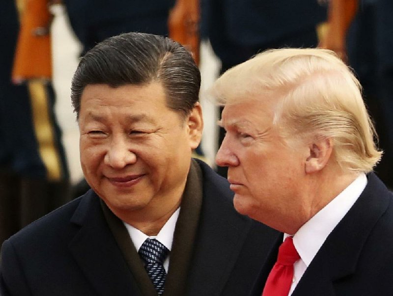 In this Nov. 9, 2017, file photo, U.S. President Donald Trump and Chinese President Xi Jinping participate in a welcome ceremony at the Great Hall of the People in Beijing, China. 