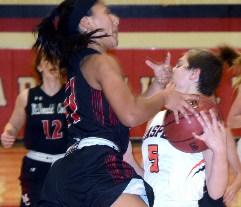 RICK PECK/SPECIAL TO MCDONALD COUNTY PRESS McDonald County's Rita Santillan gets fouled by Jasper's Sydney Webb while driving to the basket during the Lady Mustangs' 49-36 win on Nov. 29 in the Freeman Sports Medicine CJ Classic at Carl Junction High School. Santillan scored 13 of her team-high 19 points in the fourth quarter to lead the Lady Mustangs to their first win of the season.