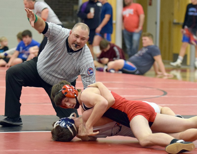 RICK PECK/SPECIAL TO MCDONALD COUNTY PRESS McDonald County's Jacob Owens pins Clyde Harrier of Rogers heritage to help the Mustangs claim a 40-39 win on Nov. 27 at MCHS.