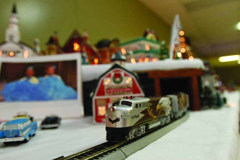 In the country village, a train can be seen winding past a makeshift drive-in movie theater, where patrons are watching “White Christmas.” Terrance Armstard/News-Times