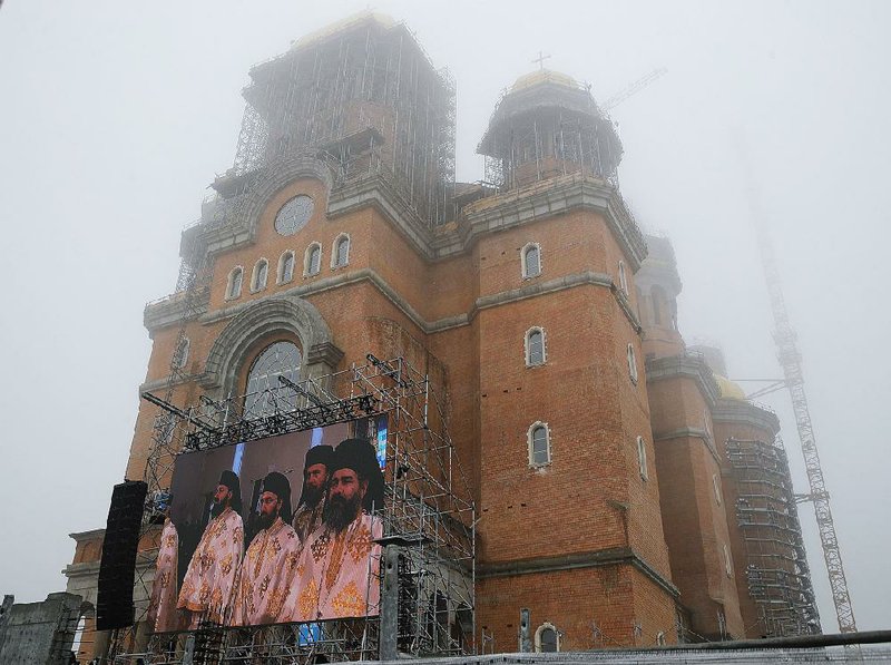 A display shows the blessing service of the National Cathedral, in Bucharest, Romania, on Nov. 25. Tens of thousands of Romanians gathered for the blessing of the Orthodox cathedral, also called the “Salvation of the People” cathedral, consecrated to mark 100 years since modern-day Romania was created in the aftermath of World War I. 