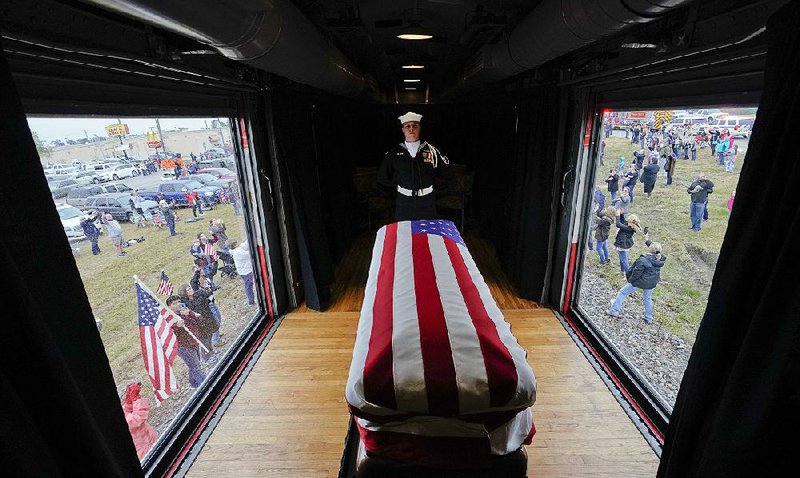 An honor guard member watches over the casket of former President George H.W. Bush as the funeral train passes through Magnolia, Texas, on Thursday. 