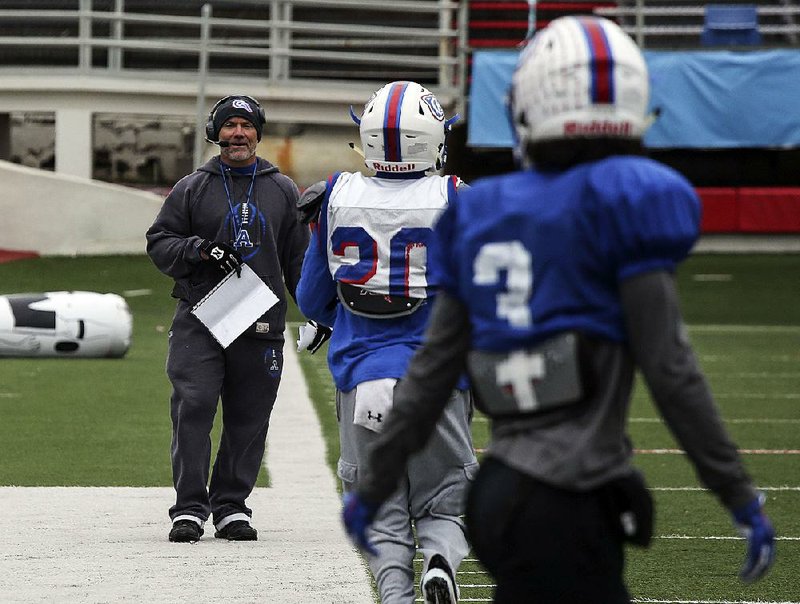 Arkadelphia Coach J.R. Eldridge (left) instructs his players during practice Thursday at War Memorial Stadium in Little Rock. The Badgers, the defending Class 4A state champions, will face Joe T. Robinson in the Class 4A state championship game at 6:30 p.m. Saturday. 