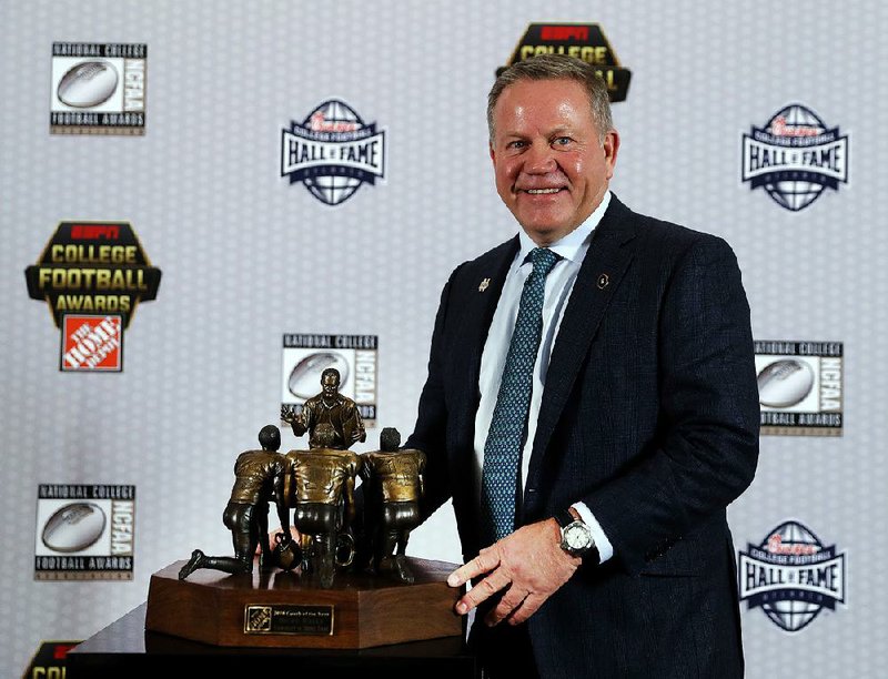 Notre Dame football coach Brian Kelly poses with the trophy after being named Coach of the Year, Thursday, Dec. 6, 2018, in Atlanta.
