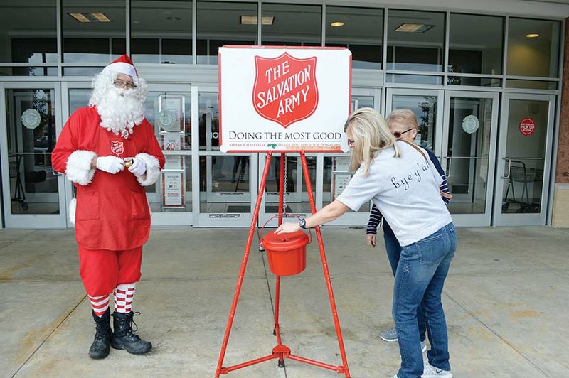 Sandy Thomas, right, puts money into The Salvation Army Red Kettle in front of Belk in Conway. Also pictured is her mother, Ruth Holsted, and bell-ringer Anthony Marrall, dressed as Santa. Capt. Patrishia Knott, corps officer for The Salvation Army Conway Corps, said donations are down this year, and volunteer bell-ringers are desperately needed.