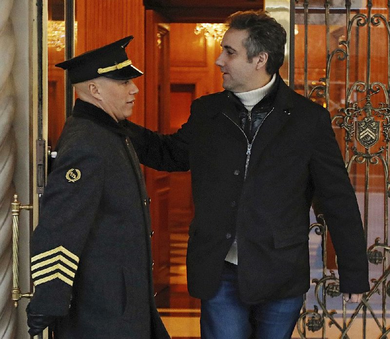 Michael Cohen greets the doorman of his Park Avenue apartment building Friday in New York as he goes out. Court filings Friday revealed Cohen’s involvement in a number of dealings at the center of the special counsel’s investigation. 