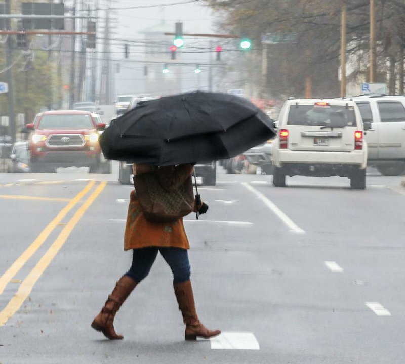 A bundled-up pedestrian hurries across West Markham Street in downtown Little Rock on Friday morning. 