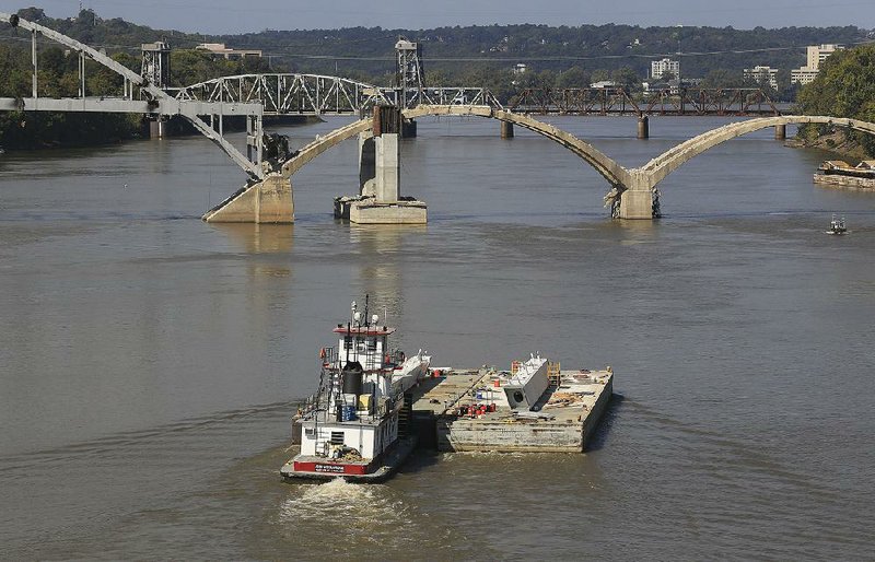 A tow boat moves a barge on the Arkansas River, part of the McClellan-Kerr Navigation System. 