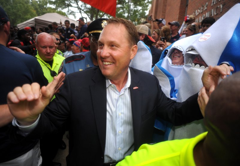 FILE - In this Oct. 24, 2015, file photo, Ole Miss Rebels head coach Hugh Freeze walks through fans on the way to the stadium in Oxford, Miss. Liberty has hired former Mississippi coach Hugh Freeze to lead its football program. A person familiar with the situation told The Associated Press that the Flames have tabbed Freeze as their next coach. The person spoke to the AP on the condition of anonymity because neither the school nor Freeze has publicly announced the decision. Liberty has scheduled a news conference to &quot;name Liberty's next head football coach&quot; for Friday afternoon, Dec. 7, 2018. (Bruce Newman/The Oxford Eagle via AP, File)