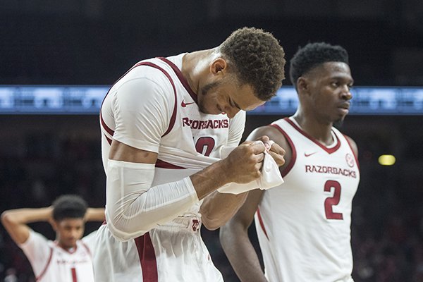 Arkansas forward Daniel Gafford (left) walks off the floor with teammate Adrio Bailey (2) after missing a shot as time expired during a game against Western Kentucky on Saturday, Dec. 8, 2018, in Fayetteville. 