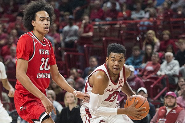 Arkansas guard Mason Jones drives past Western Kentucky defender Dalano Banton during a game Saturday, Dec. 8, 2018, in Fayetteville. 