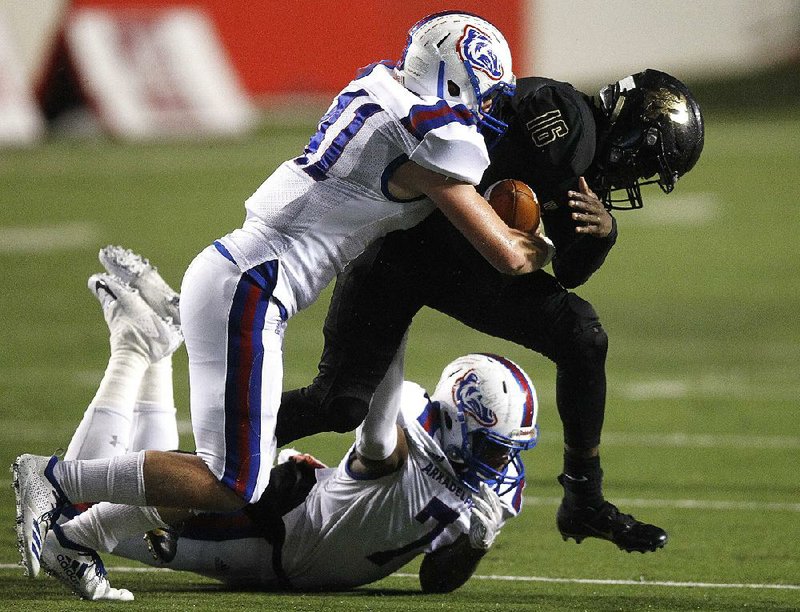 Arkadelphia defenders Carlos Haynie (left) and Sammy Hawthorne tackle Joe T. Robinson running back Mekel Kentle. 