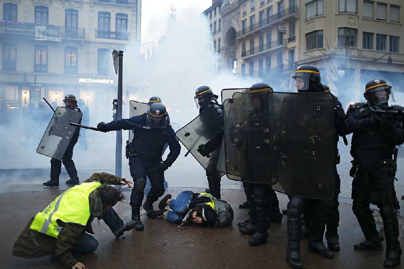 Riot police officers subdue protesters during clashes Saturday in Lyon in central France. 