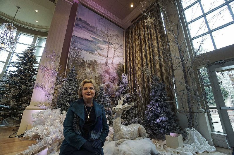 Susan Hutchinson stands in front of one of two panels depicting Spavinaw Creek that are part of the Christmas display in the Janet M. Huckabee Grand Hall at the Governor’s Mansion. 