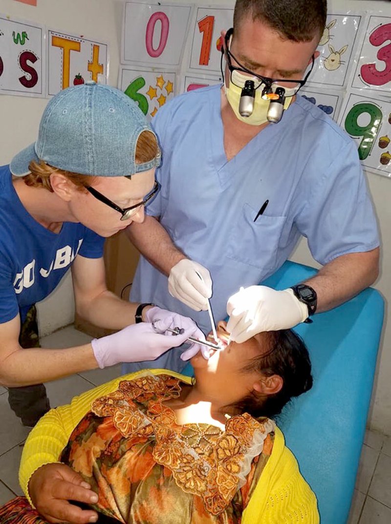 Photo submitted Christian Foust, left, a nursing student from John Brown University, and Dr. Trent McCord, of Mint Dental Care in Centerton, did a dental procedure on a patient at the Heart of Love Clinic in Guatemala City, Guatemala, during a Dustin's Dream mission trip in June. Details about the trip will be shared during Dustin's seventh Heavenly Birthday Party on Dec. 15. The fundraiser has a new location at Camp Siloam.