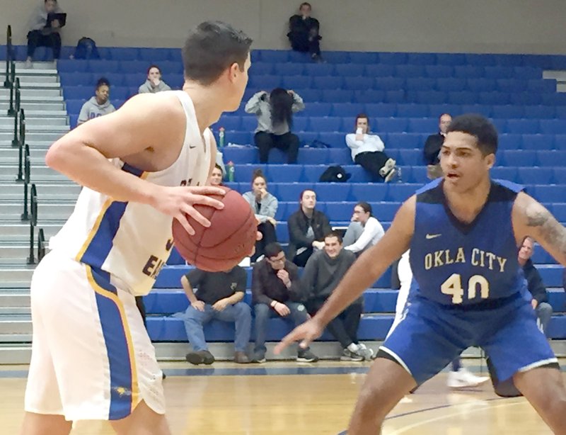 Graham Thomas/Siloam Sunday John Brown senior Josh Bowling, left, looks to pass as Oklahoma City's Anthony Davis defends during Thursday's game at Bill George Arena.