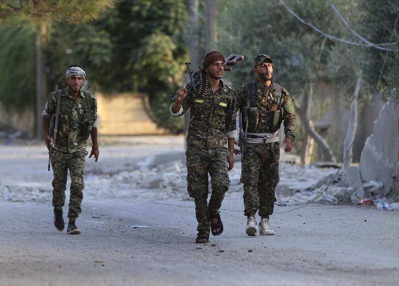  In this July 22, 2017 file photo, U.S.-backed Syrian Democratic Forces (SDF) fighters, prepare to move for a battle against the Islamic state militants, in Raqqa, northeast Syria. A year after it was routed from Iraq following a three-year devastating war that left Iraqi cities in ruin, the Islamic State group is fighting to hang on to its last enclave in Syria, engaging in deadly battles with U.S.-backed forces in the country's east near the Iraqi border. (AP Photo/Hussein Malla, File)